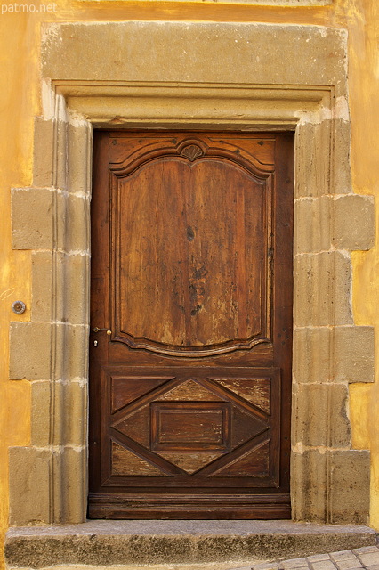 Photo d'une ancienne porte en bois entoure de vieilles pierres  Cogolin