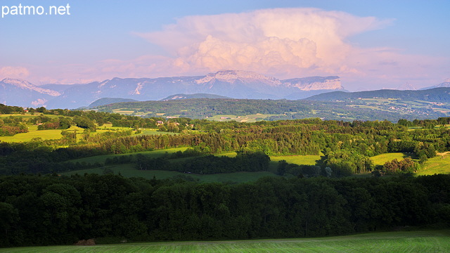 Image d'un paysage rural de Haute Savoie avec une formation nuageuse au dessus des montagnes