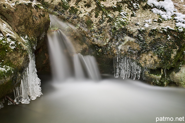 Photo d'une petite cascade au milieu des glaons dans le torrent du Fornant en Haute Savoie
