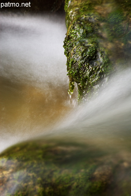 Photographie de l'eau cascadant entre les rochers moussus de la rivire du Fornant