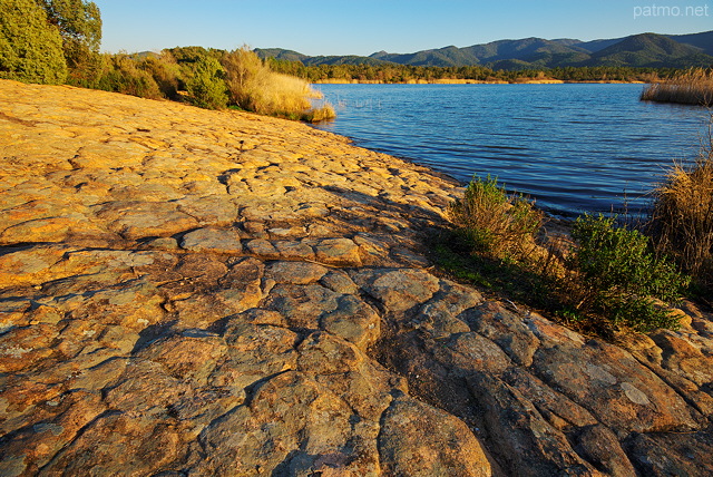 Photographie d'une petite plage rocheuse au bord du lac des Escarcets dans le Var