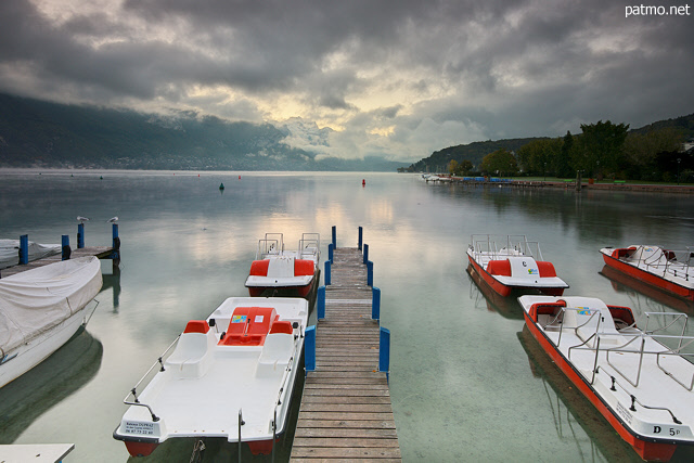 Photo of Annecy lake under a cloudy sky by an autumn morning