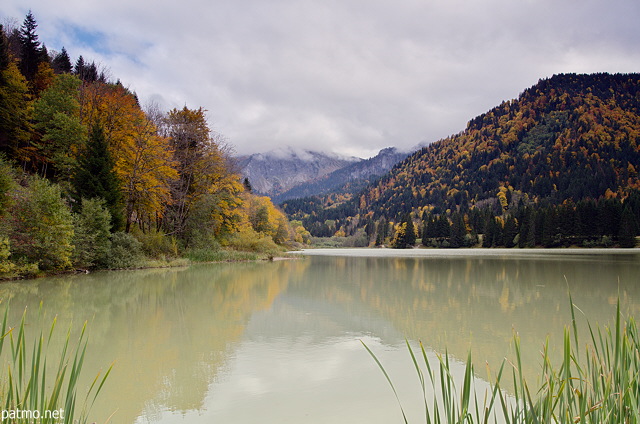 Image of lake Vallon under a cloudy sky and surrounded by the autumn forest