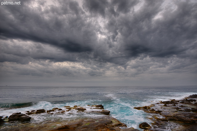 Photo of the mediterranean coast under an impressive cloudy sky