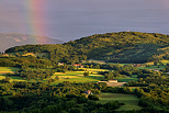 Photographie de la campagne de Haute Savoie sous un ciel d'orage travers par un arc en ciel