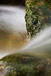 Photographie de l'eau cascadant entre les rochers moussus de la rivire du Fornant