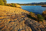 Photographie d'une petite plage rocheuse au bord du lac des Escarcets dans le Var