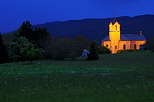Photographie à l'heure bleue de l'église de Franclens illuminée.