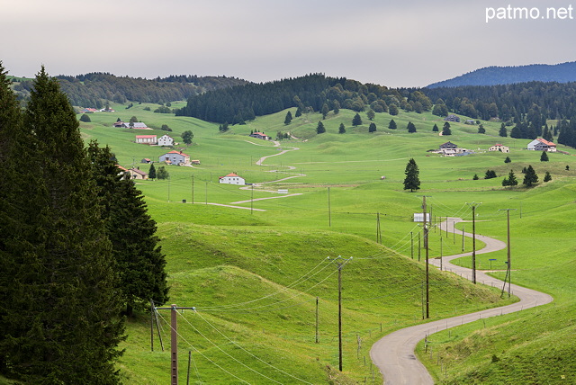 Image of a rural landscape with farms and little road in french Jura