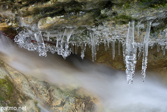 Image de stalactites de glace au dessus de l'eau courante dans la rivière du Fornant - Haute Savoie
