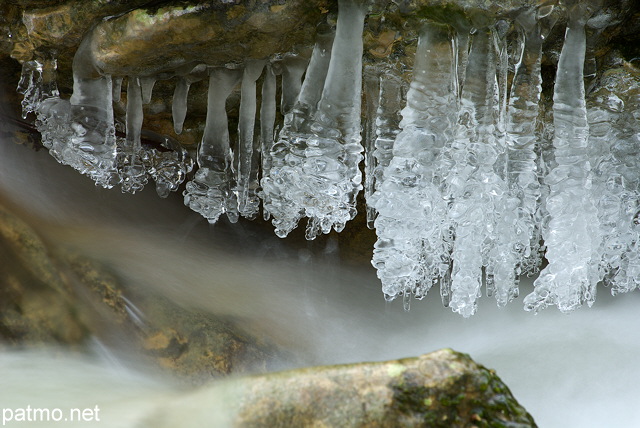 Photo de stalactites de glace suspendues au dessus de l'eau du Fornant en Haute Savoie.