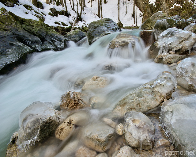 Photographie de petites cascades entre rochers et glaçons dans la rivière de la Valserine