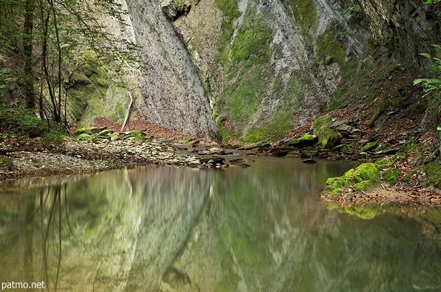 Image of cliff reflection on the water of Fornant river