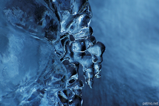 Photograph of tiny ice stalactites over the water of Fornant river