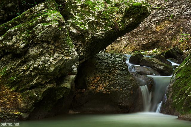 Photographie d'une petite cascade de printemps entre les rochers du torrent du Fornant