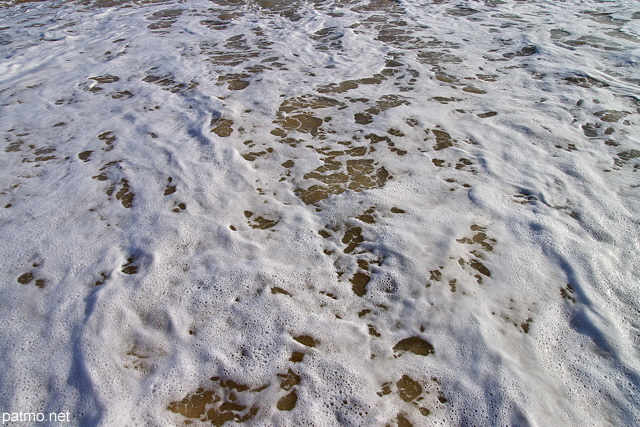 Photo de l'écume des vagues de l'océan atlantique sur une plage de Bretagne