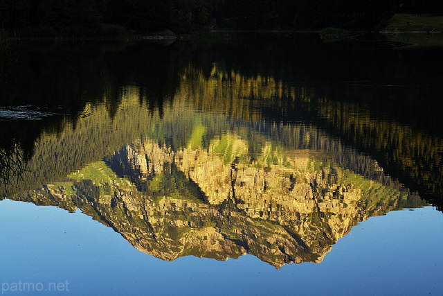 Photographie du reflet du Roc d'Enfer dans les eaux calmes du Lac de Vallon à Bellevaux