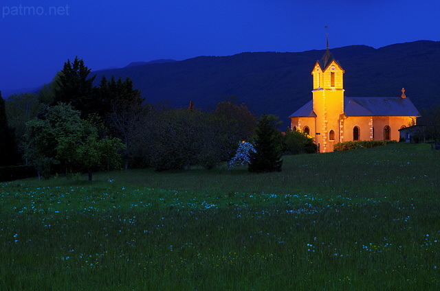 Photographie à l'heure bleue de l'église de Franclens illuminée.
