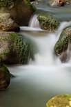 Photo en pose longue de l'eau vive cascadant entre les rochers dans le ruisseau du Fornant