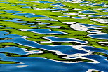 Photographie de reflets colorés à la surface du lac d'Arvouin